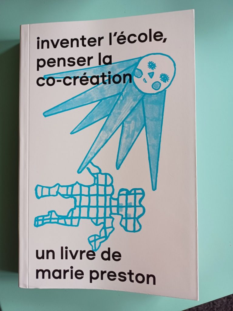 couverture de inventer l'école, penser la co-création : il y a un dessin à la ligne bleue claire d'un soleil avec un visage rayonnant sur un bonhomme-tablette de chocolat