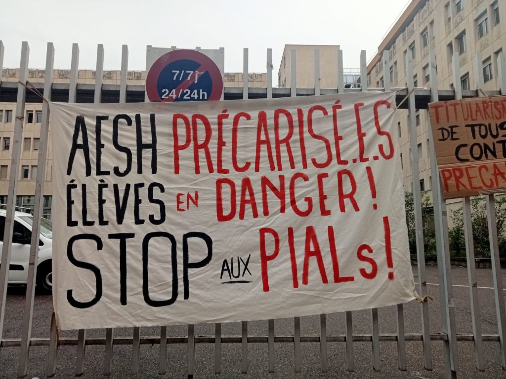 Banderole accrochée sur le portail du rectorat de Lyon le 14 octobre 2022: "AESH précarié.e.s, élèves en danger! Stop aux PIALs!"