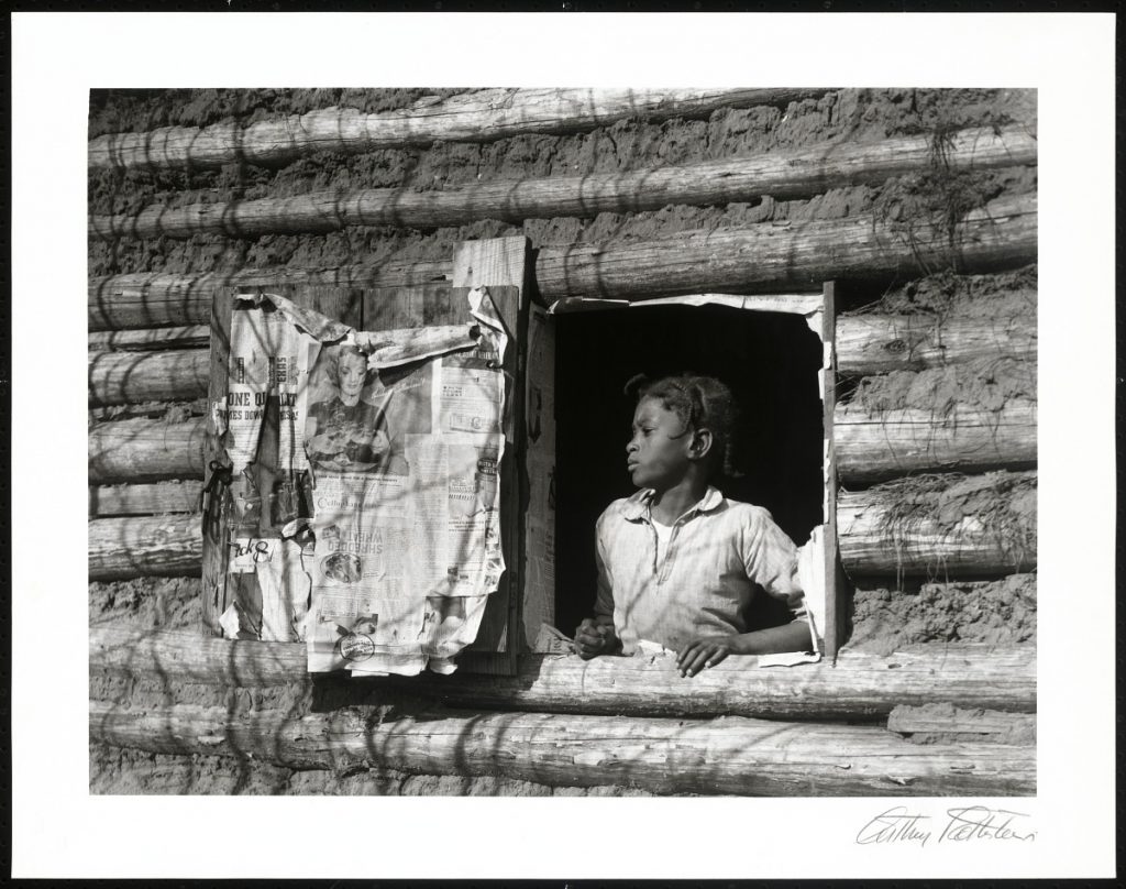 jeune fille noire dans l'encadrement d'une fenêtre