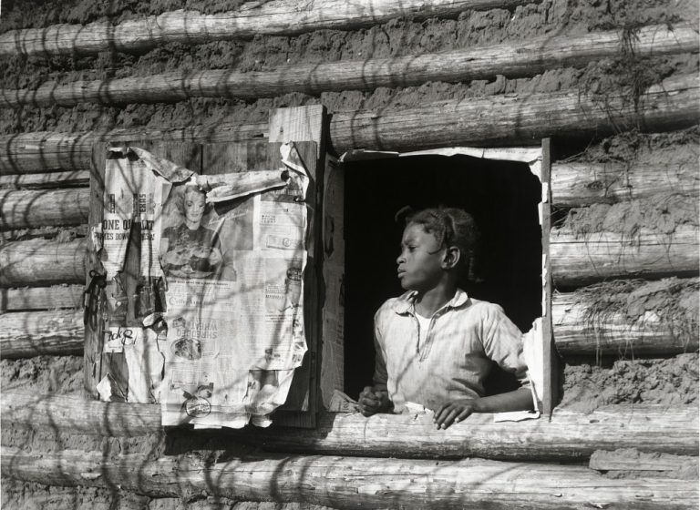jeune fille noire dans l'encadrement d'une fenêtre