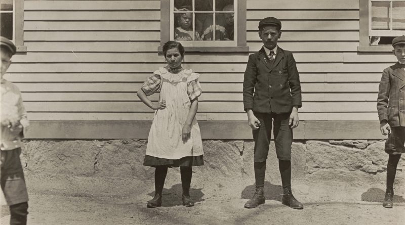 photographie ancienne de d'un frère et une soeur devant un batiment