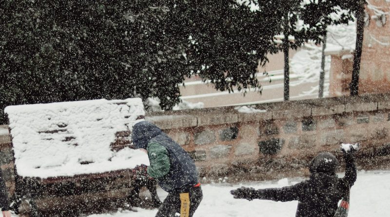 enfants faisant une bataille de boules de neige dans la ville