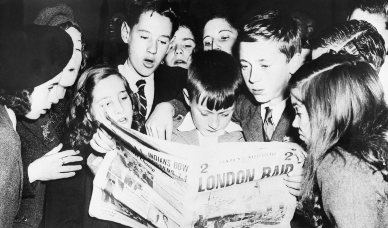 des enfants lisent un journal en anglais / photo noire et blanc